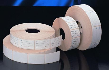 Self-adhesive white labels, with a blank or printed surface, in a roll